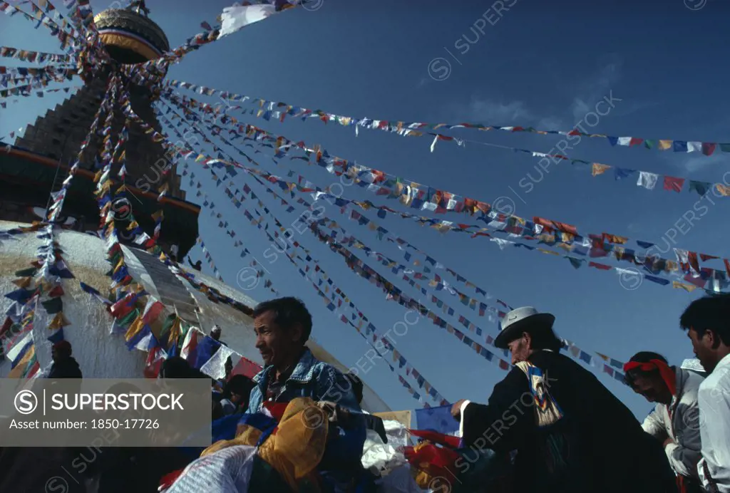 Nepal, Kathmandu, Bodhanth Stupa, Tibetans Hanging The Stupa With Prayer Flags For New Year Celebrations.