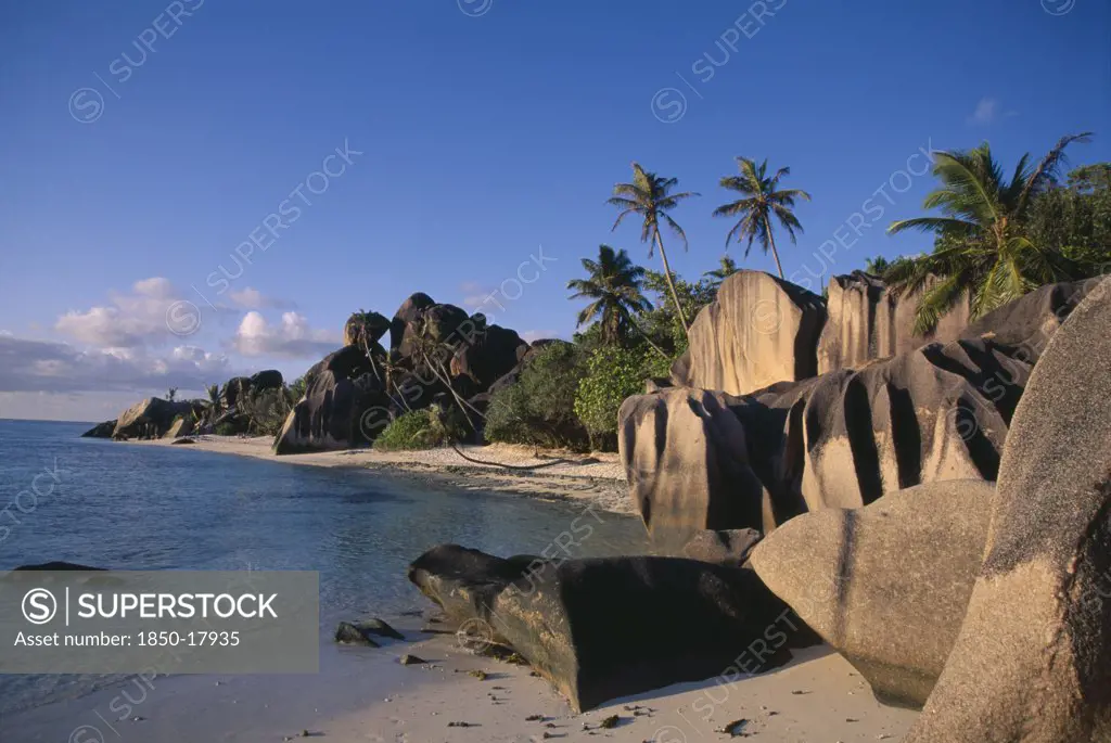 Seychelles, La Digue , Anse Source D Argent, Rock Formations Along The Coast With Palm Trees And Green Vegetation And Turquoise Sea