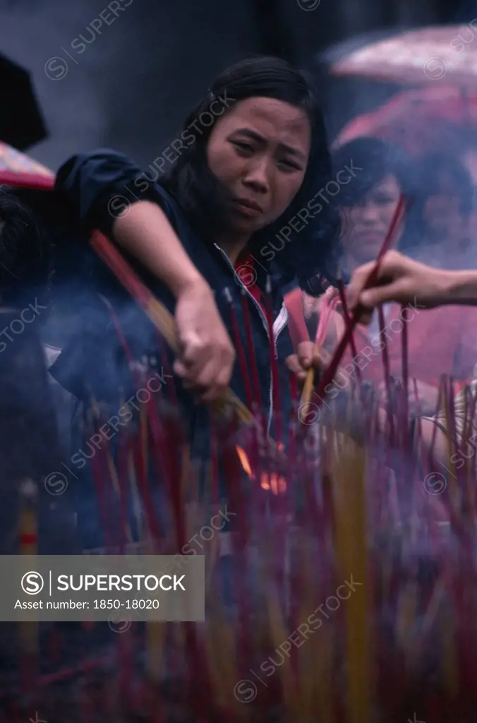 China, Guangzhou, People, Young Woman Lighting Incense At Temple.