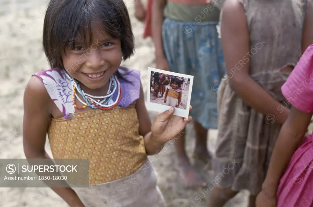 Colombia, Amazonas, Santa Isabel, Macuna Indian Girl Holding A Polaroid Photograph Of Herself.
