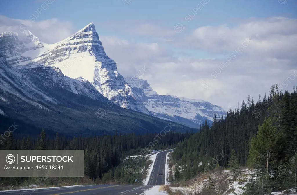 Canada, Alberta, Banff National Park, Trans-Canada Highway Through Mountain Landscape With Pine Forests And Melting Snow.