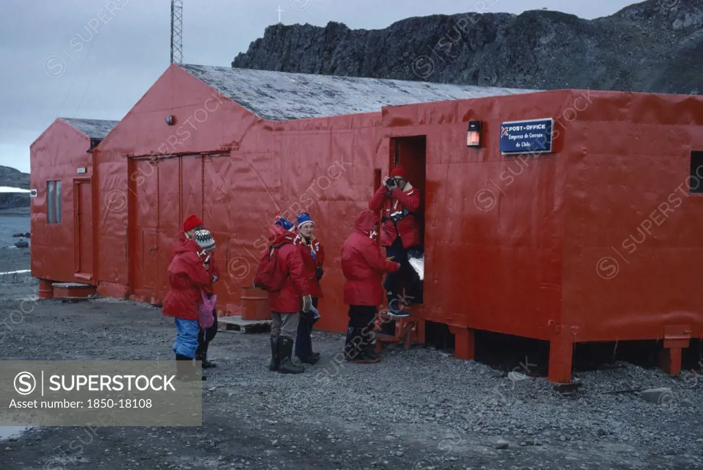 Antarctica, King George Island, Teniente Marsh Station. Tourists Wearing Red Jackets Outside Post Office