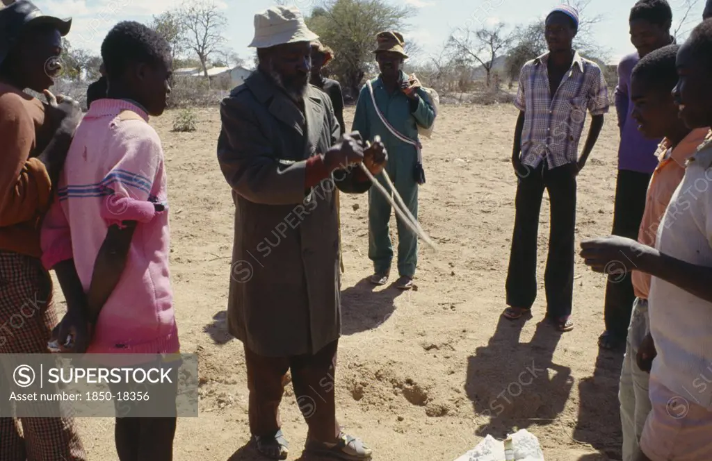 Zimbabwe, Buhera District, Water Prospector Using Divining Rods To Show Where Water Can Be Found.