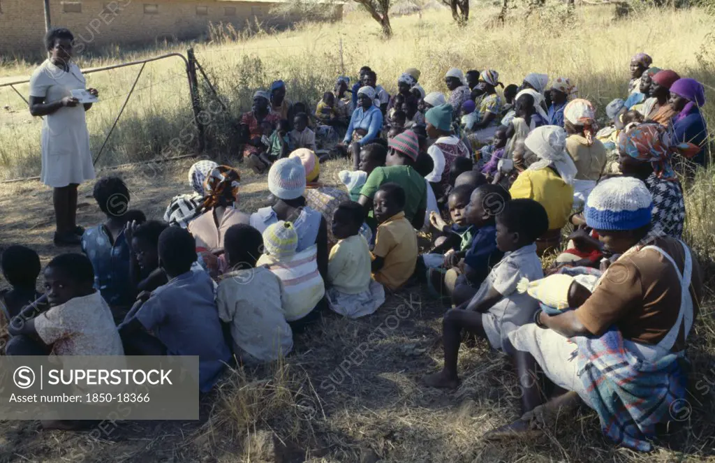 Zimbabwe, People, Family Planning Association Education Officer And Distributor Talking To Women On Farming Compound.