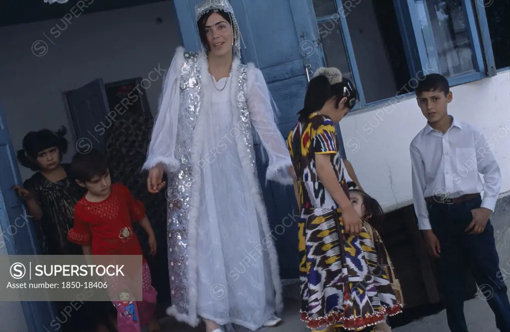 Tajikistan, Wedding, 'The Bride Wearing A White Dress And Silver Jacket, With Children Around Her At A Village Wedding.'