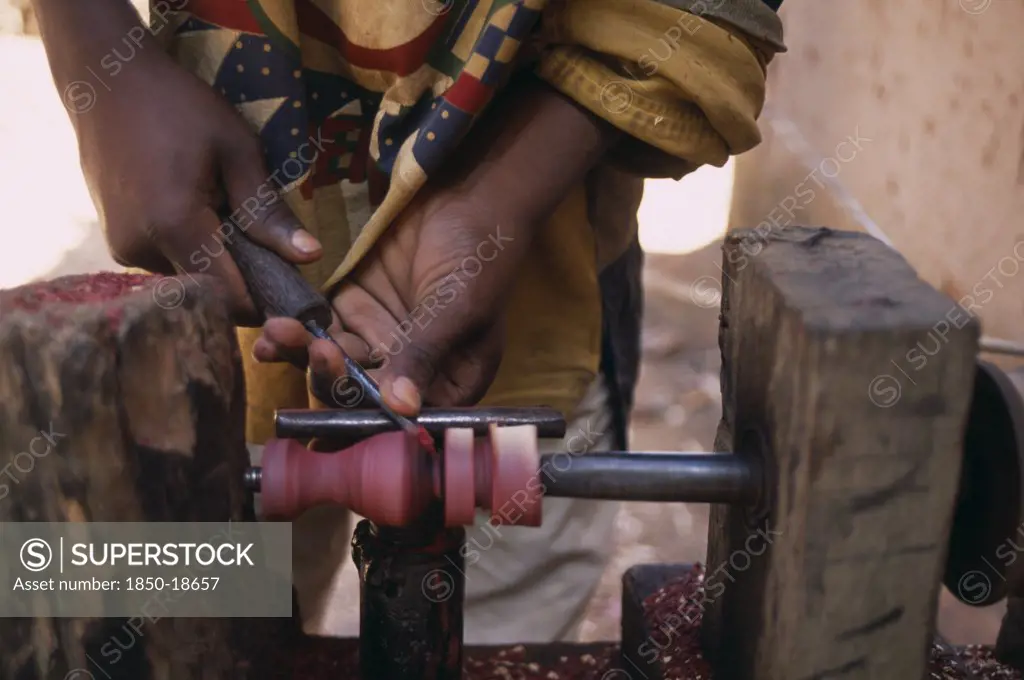 Madagascar, Ambositra, Close Up Of The Hands Of An Artisan Carving A Piece Of Rosewood