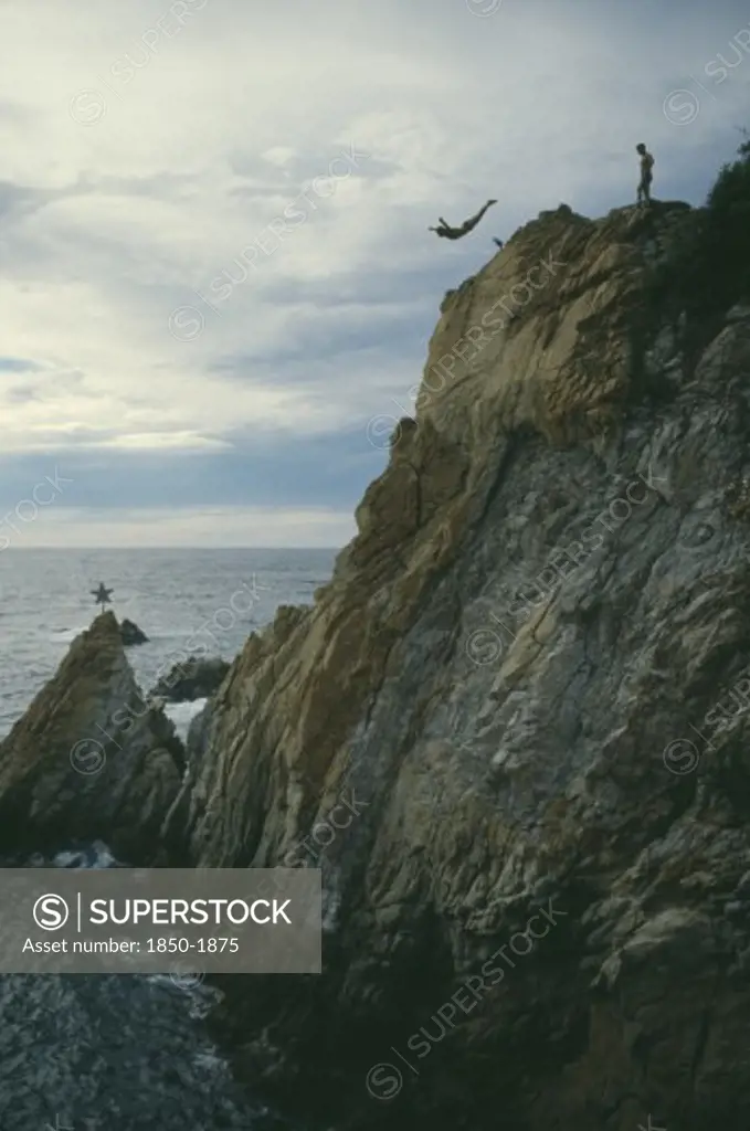 Mexico, Guerrero, Acapulco, Cliff Diver In Mid Air With Sea Below