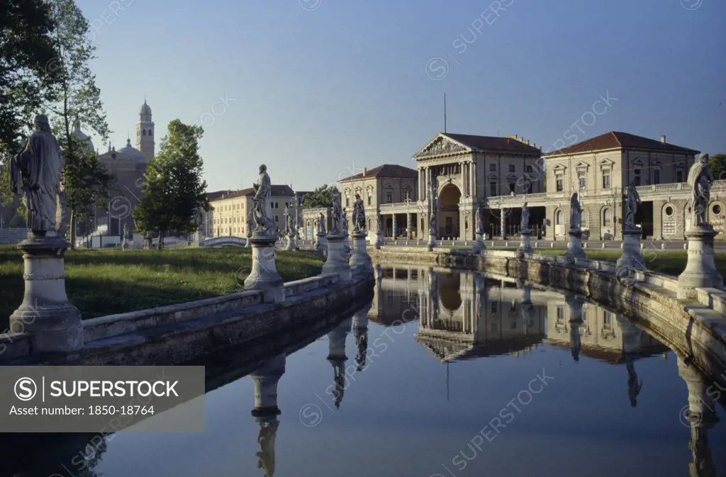 Italy, Veneto, Padua, Prato Della Valle.  Canal Surrounding Oval Green Island Along Which Stand Statues Of Famous Cultural Figures.