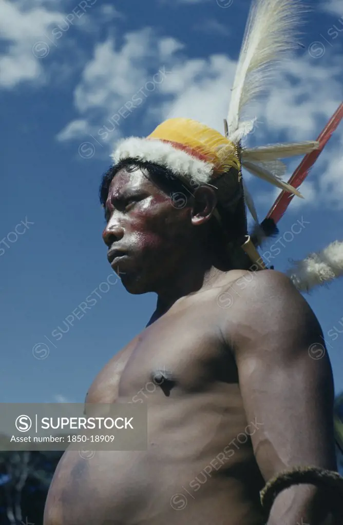 Colombia, Vaupes Region, Tukano Tribe, 'Man With Ceremonial Feather Head-Dress  Crown Of White Egret Down, Macaw And Toucan Breast Feathers, Royal Crane And Macaw Tail Feathers; Forest Nut Arm Band, Red Achiote Berry Facial Paint'