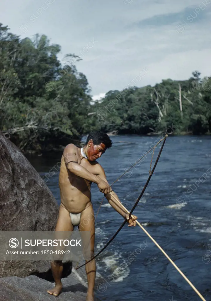 Colombia, Vaupes Region, Tukano Tribe, Man Fishing With Macana Wood Bow And Bamboo Arrow In Rio Piraparana
