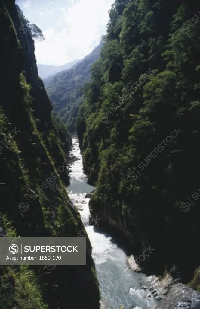 Taiwan, Near Tien-Hsiang, Deep Gorge With Fast Flowing River At The Bottom Of The Steep Cliffs Covered With Greenery