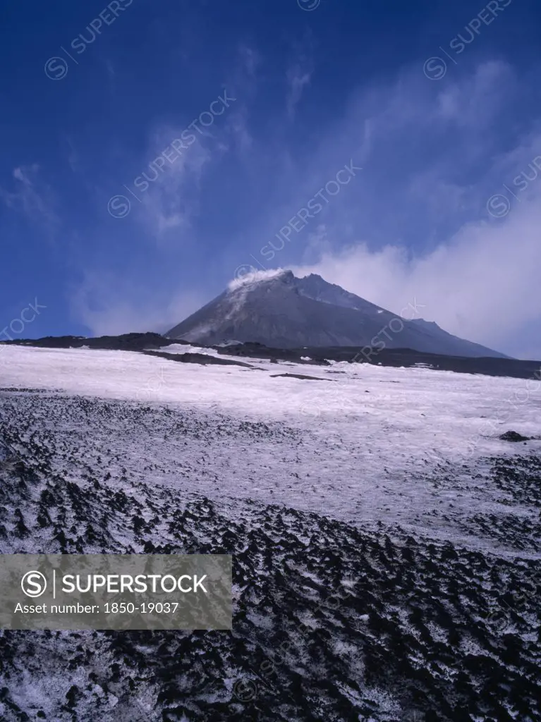 Italy, Sicily, Mount Etna, The Summit Cone Seen From Across A Lava Field Covered With Snow.