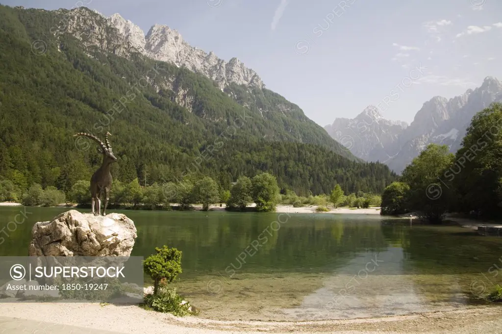 Slovenia , Kranjska Gora, Julian Alps, The Famous Ibex Statue At Lake Jasna Just A Ten Minute Walk Form The Centre Of The Town At The Entrance To Velika Pisnica Near The Road To Vrsic Mountain Pass With Mounts Razor And Prisank In Th Background