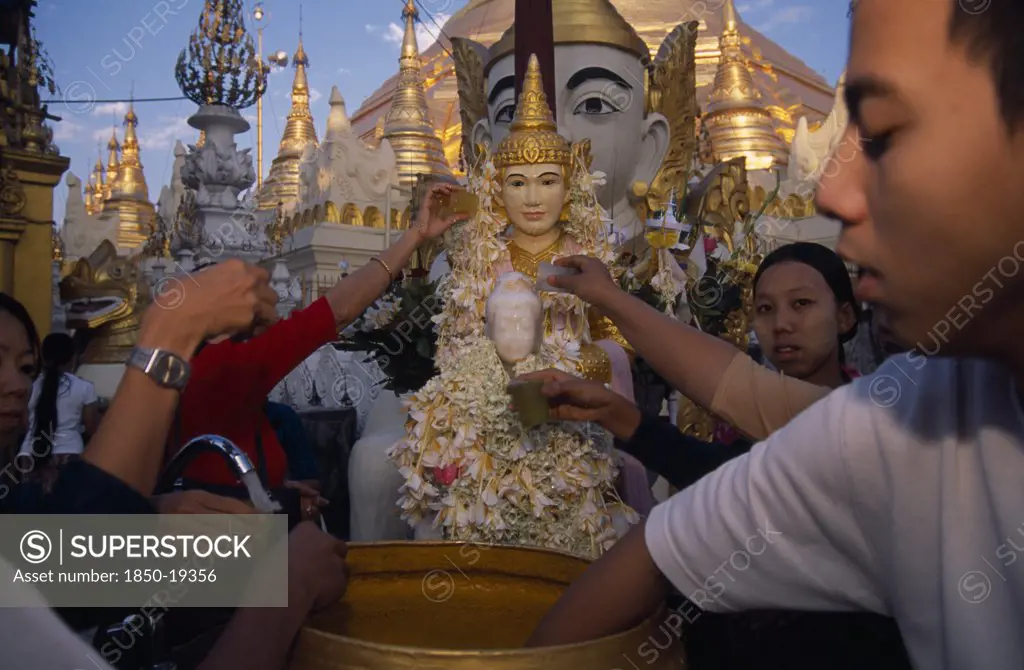 Myanmar, Yangon, People Making Offerings Of Flowers And Water At Shrine In Shwedagon Pagoda.