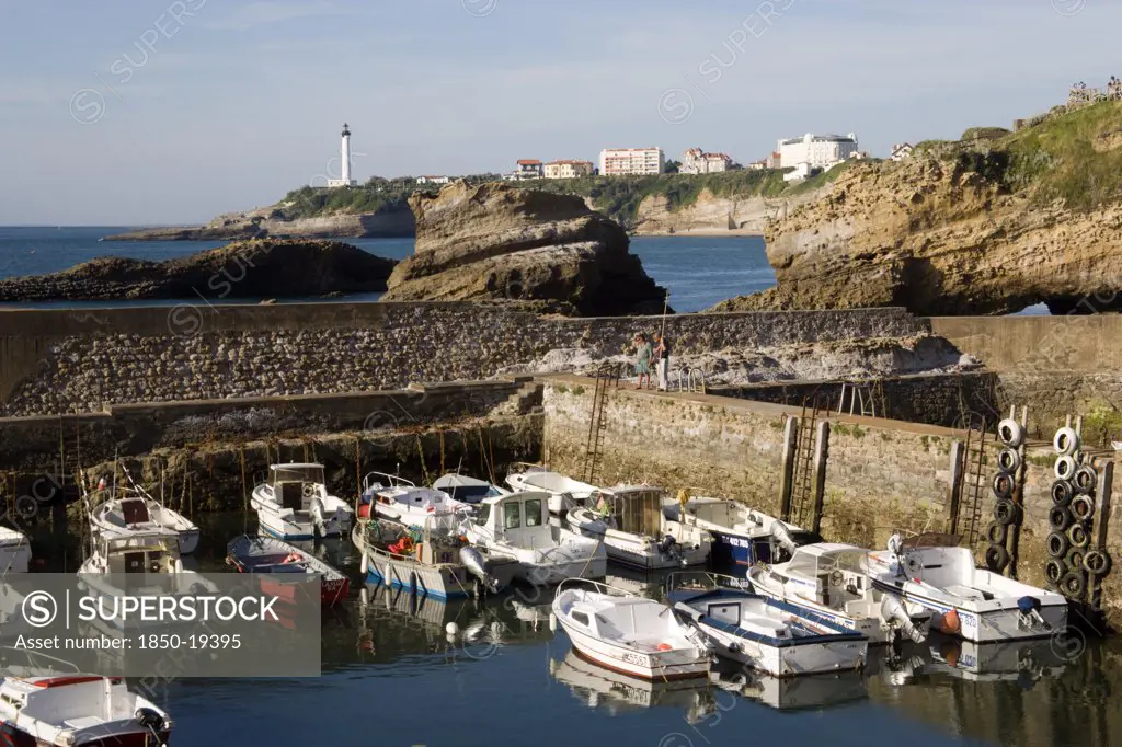 France, Aquitaine Pyrenees Atlantique, Biarritz, The Basque Seaside Resort On The Atlantic Coast. Boats In The Safe Harbour Of The Port Des Pecheurs With The Lighthouse In The Distance.
