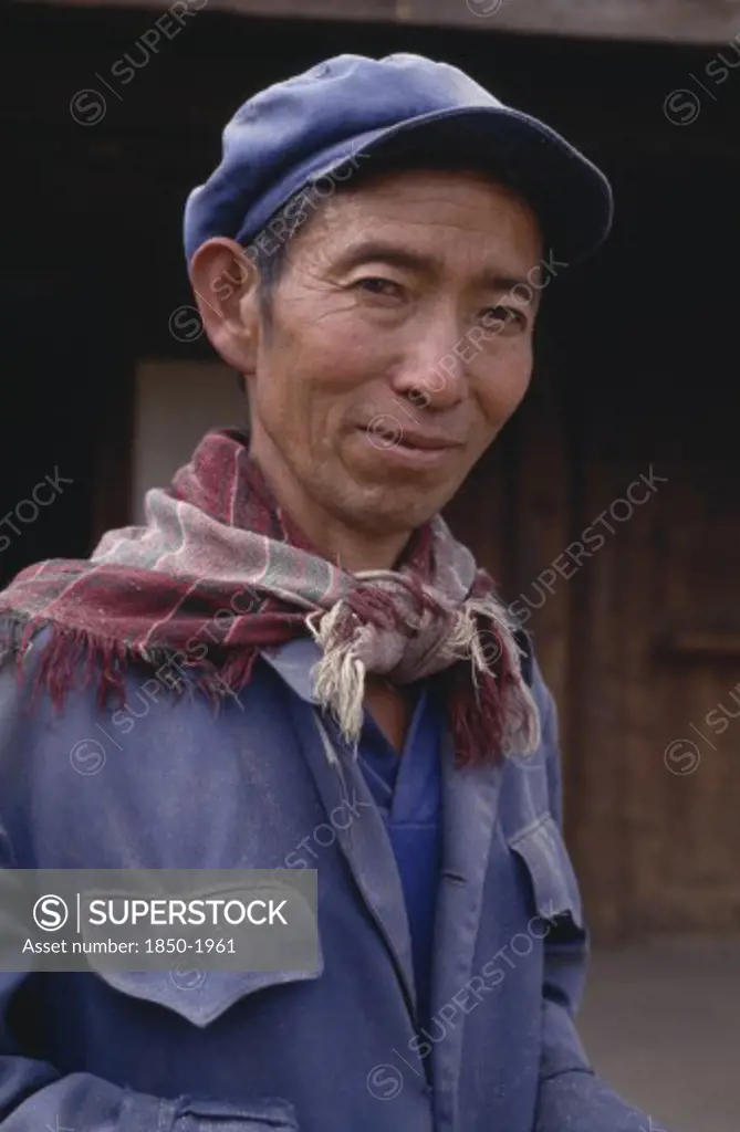 China, Yunnan, Baisha, Portrait Of A Naxi Man Wearing A Cap And Scarf