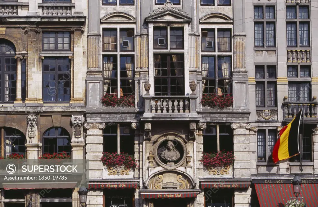 Belgium, Brabant, Brussels, Grand Place.  Part View Of Building Facade With Stone Balconies  Flower Filled Window Boxes And Tall Multi-Paned Windows. Unesco World Heritage Site