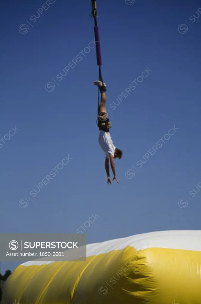 Sport, Bungee Jumping, Jumper Dangling Above Large Inflatable.