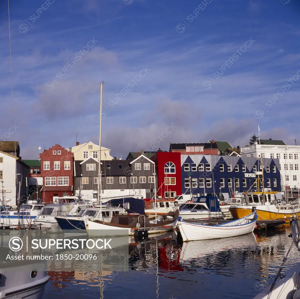 Denmark, Faroe Islands, Torshavn, Boats Moored In Harbour With Colourful Waterfront Buildings Behind.