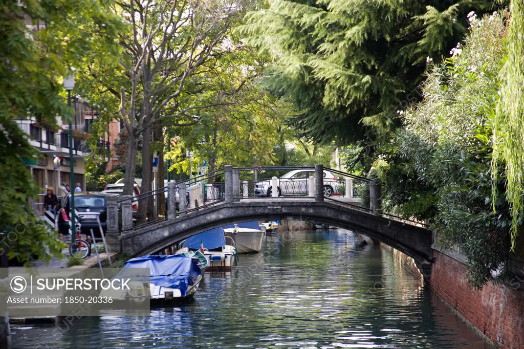 Italy, Veneto, Venice, A Bridge Across A Canal On The Lido
