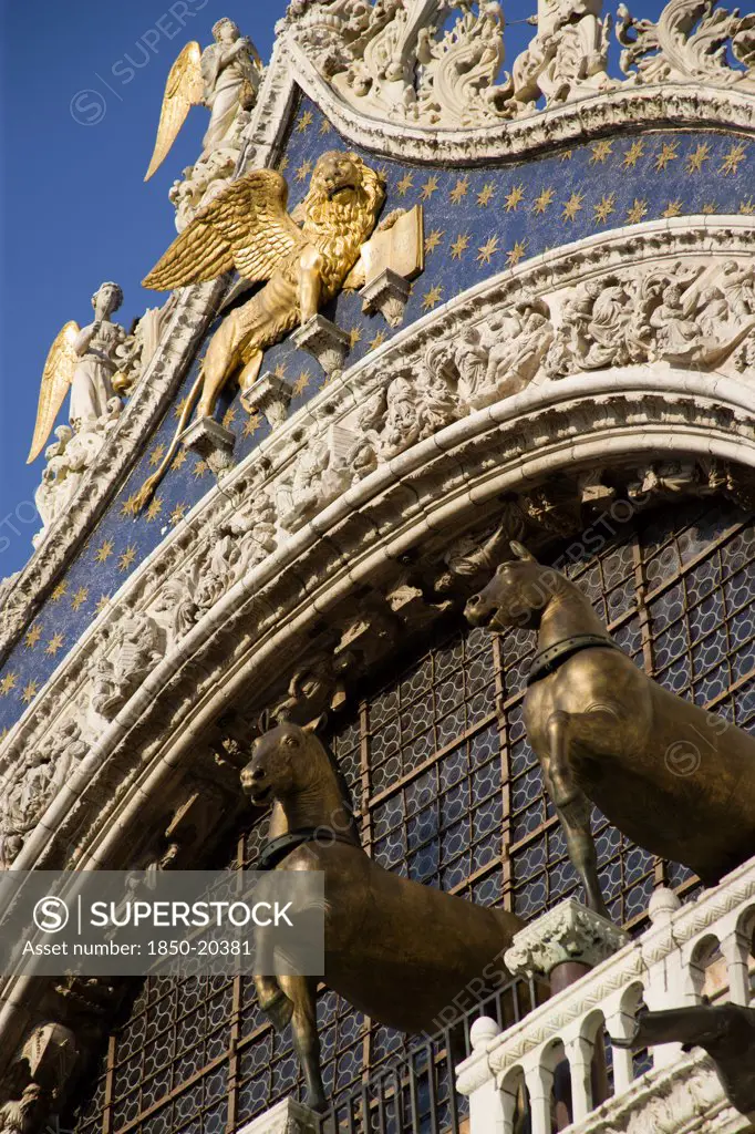 Italy, Veneto, Venice, The Bronze Horses Of St Mark And The Winged Lion Of St Mark Below Angels On The Facade Of St Marks Basilica