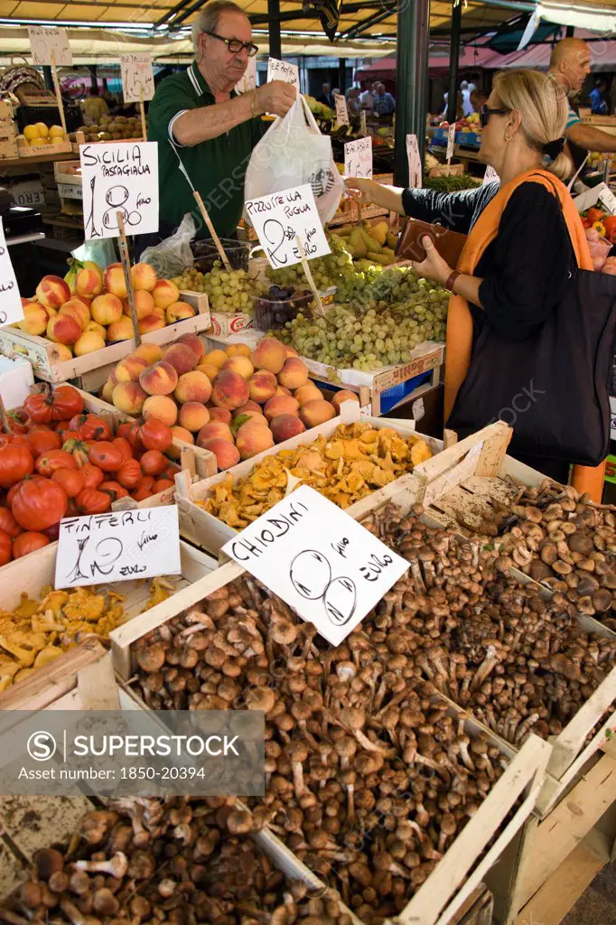 Italy, Veneto, Venice, Fruit And Vegetable Stall In The Rialto Market With Shopper And Vendor