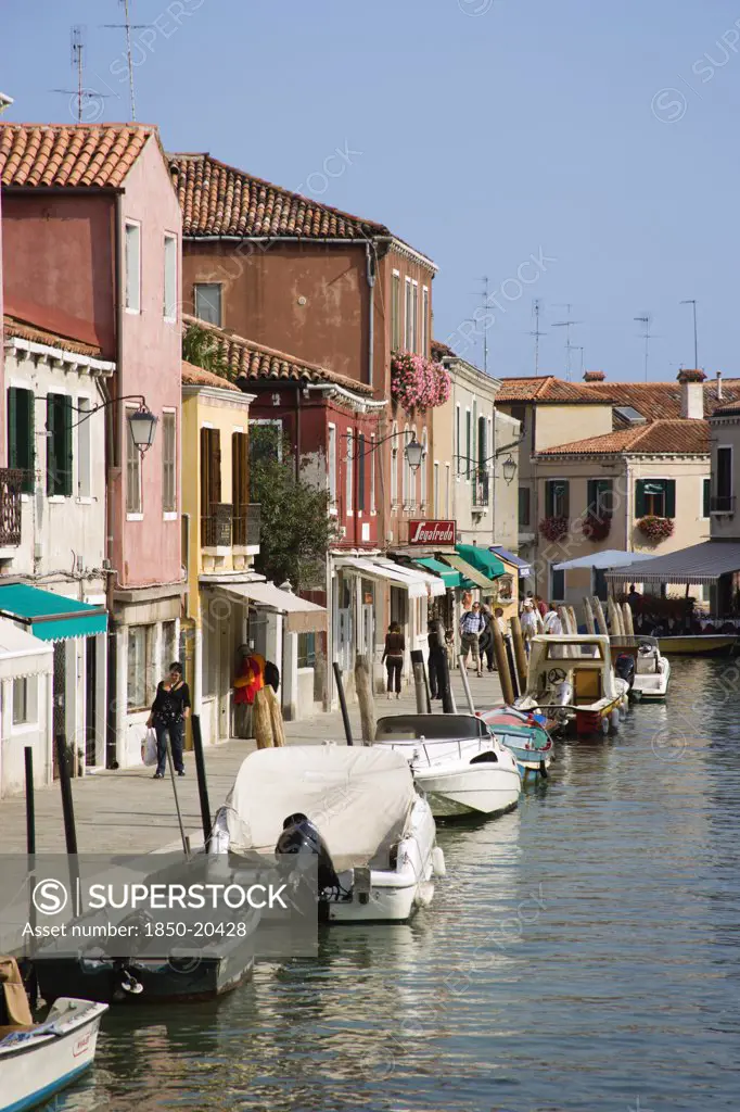 Italy, Veneto, Venice, Tourists Walking Past Shops Along The Fondamenta Dei Vetrai With Boats Moored On The Rio Dei Vetrai Canal On The Lagoon Island Of Murano