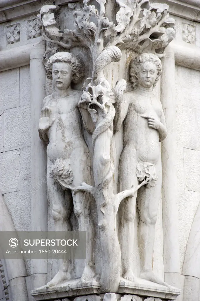 Italy, Veneto, Venice, A Stone Carving Of Adam And Eve With The Serpent In The Tree On The Corner Of The Doges Palace By The Piazzetta