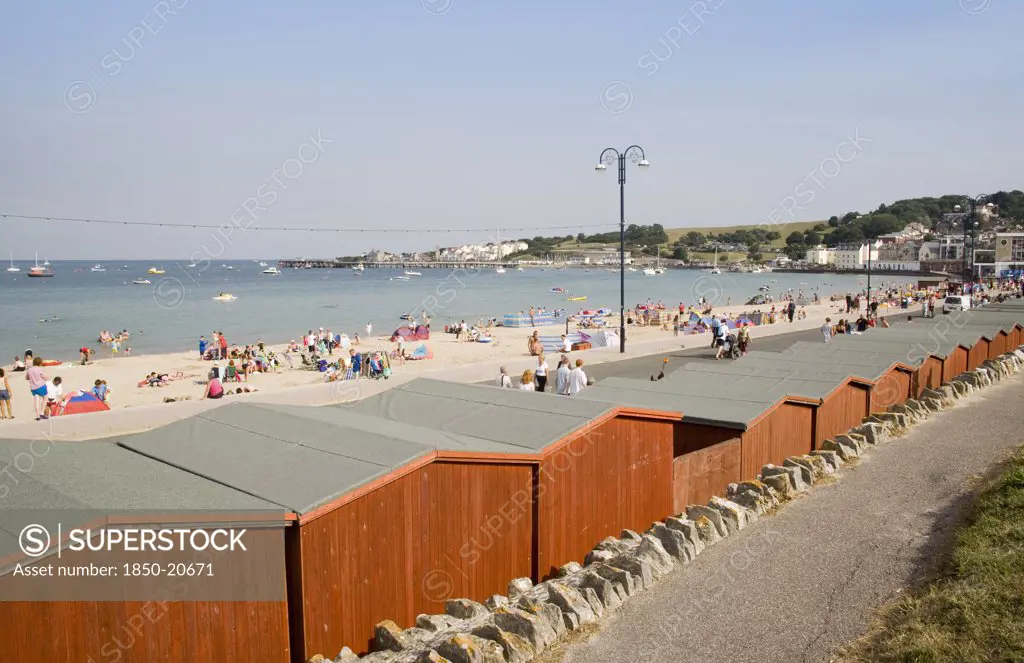 England, Dorset, Swanage Bay, View Across Beach Hut Roofs Towards Sandy Stretch Of Beach And Sea