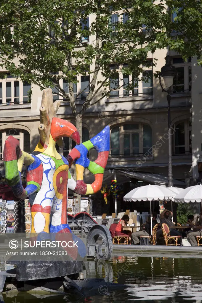 France, Ile De France, Paris, People Sitting At Tables Under Umbrellas Beside The Colourful Contemporary Fountains By Niki De Saint Phalle And Jean Tinguely In Place Igor Stravinsky Beside The Pompidou Centre In Beauborg Les Halles