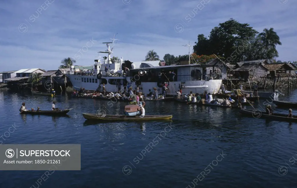 Pacific Islands, Melanesia, Solomon Islands, 'Malaita Province, Lau Lagoon. Weekly Boat Service Visiting Foueda Island Attracting Crowds In Canoes.  Thatched Housing Behind.  '