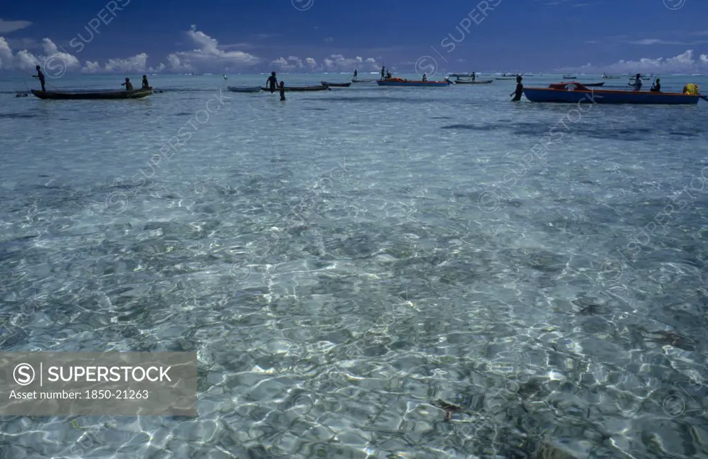 Pacific Islands, Melanesia, Solomon Islands, 'Malaita Province, Lau Lagoon. Distant Fishing Team And Boats.  Expanse Of Turquoise Sea With Light Reflections In Foreground And Blue Sky.'