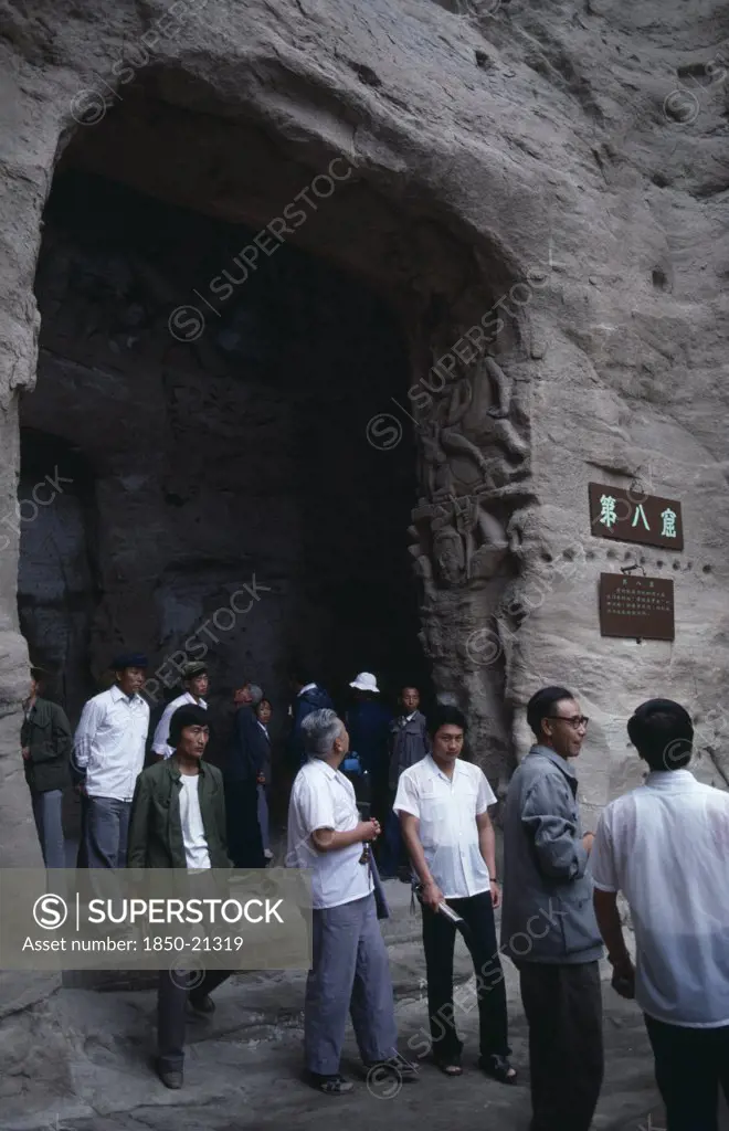 China, Shanxi, Datong, Yungang Caves.  Chinese Visitors At Cave Entrance In Ancient Buddhist Site Containing Carvings Dating From Ad 386 - 534.