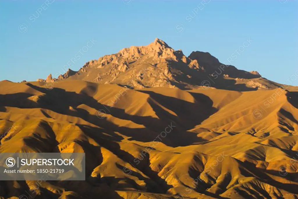 Afghanistan, Bamiyan Province, Bamiyan, Late Afternoon Sun Glows On Mountains Near The Empty Niche Where The Famous Carved Budda Once Stood (Destroyed By The Taliban In 2001)