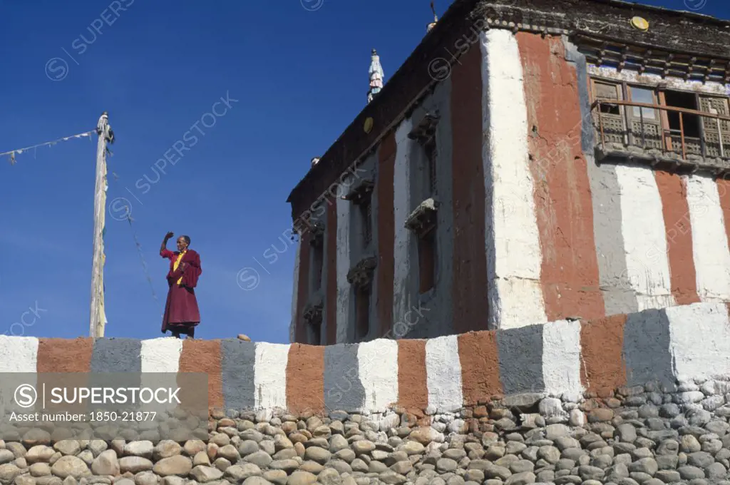 Nepal, Mustang, Tsarang Gompa, 'Tibetan Buddhist Monk Looking Out From Monastery Terrace, Shielding His Eyes From The Sun.'