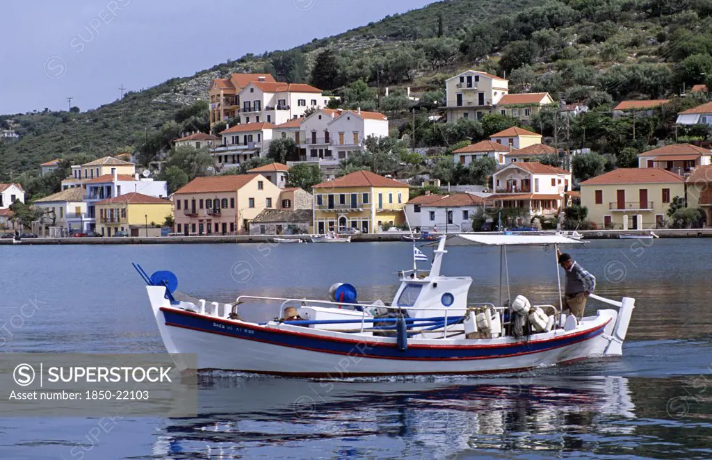 Greece, Ionian Islands, Ithaca, Vathi. Boat Moving In Harbour And Vathi Town Behind.