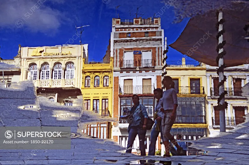 Spain, Andalucia, Seville, Reflection Of Buildings And Pedestrians In Plaza De San Francisco.