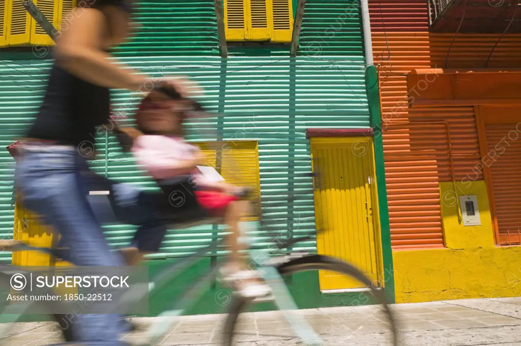 Argentina, Buenos Aires, Cyclist Passing Colourful Houses In La Boca.