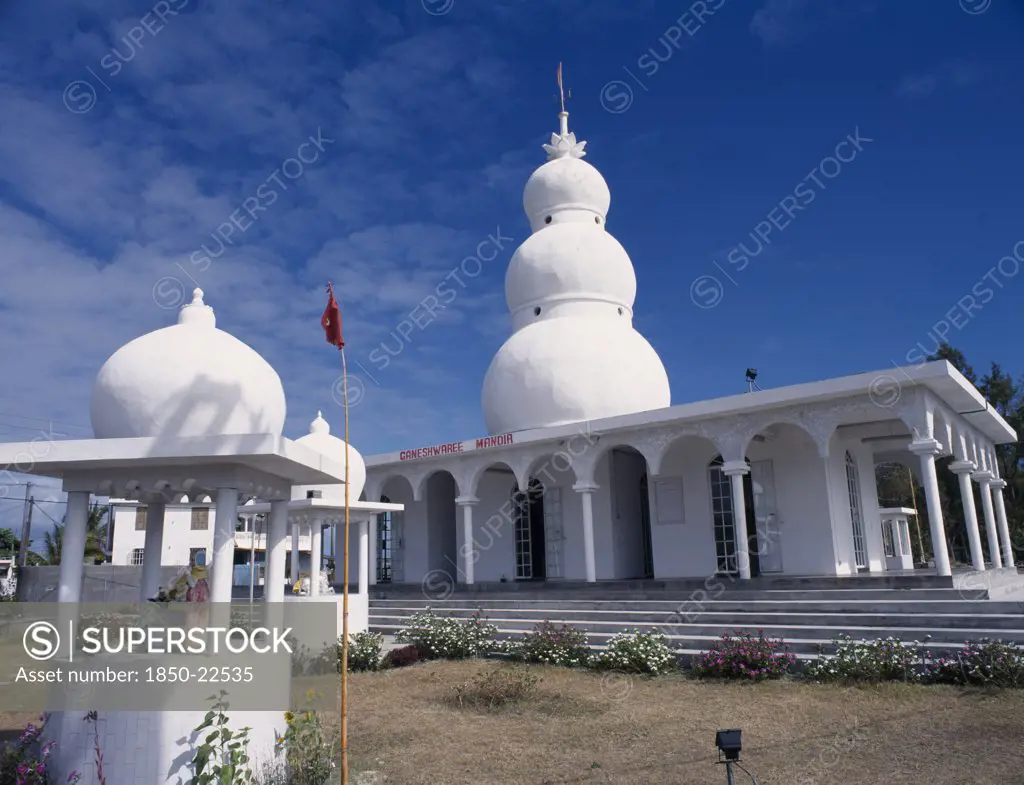 Mauritius, East Coast, Religion, 'Hindu Temple Exterior With Steps To Colonnaded Entrance And White, Three Dome Spire Above.  Small Kiosks With Statues In Foreground.'