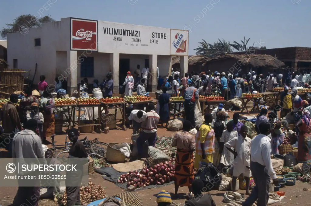 Malawi, Jenda, 'Crowded Market Scene, Fruit And Vegetable Stalls With Trading Centre Building Behind.'