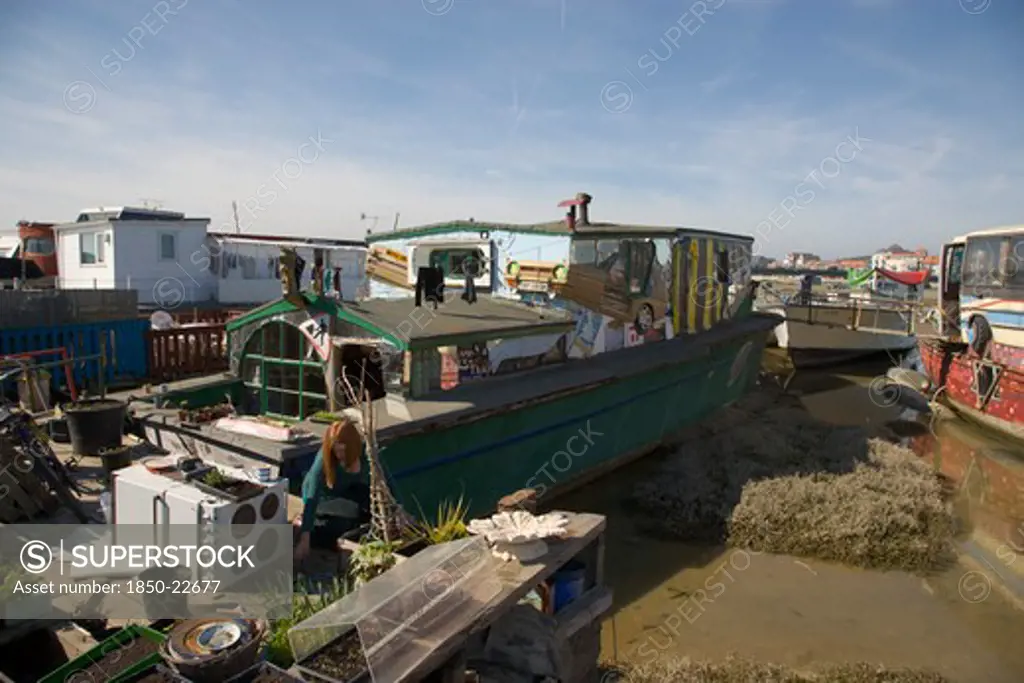 England, West Sussex, Shoreham-By-Sea, 'Houseboat Moored Along The Banks Of The River Adur.  Former Barges Converted Into Homes With The Use Of Various Bits Of Junk, Including Cars, Buses And Washing Machines.'