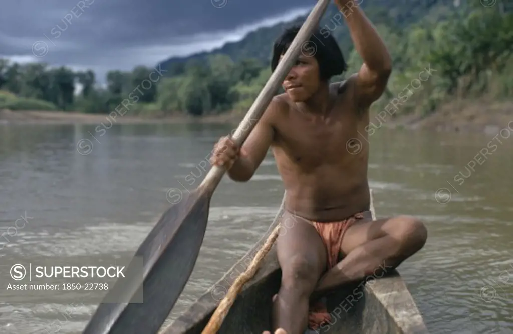 Colombia, Choco, Embera Indigenous People, Embera Man Using Single Oar To Steer Wooden Dug Out Canoe Along Rio Baudo. Pacific Coastal Region Boat Piragua Tribe