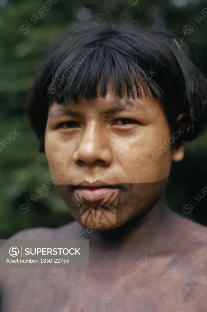 Colombia, Choco, Embera Indigenous People, Portrait Of Young Embera Man Named Rio Verde On Rio Condoto  With Lower Face And Body Painted With Black Dye Extracted From The Inedible Jagua Fruit  Used As Decoration For Tribal Rituals And Festivals. Pacific Coastal Region Tribe Body Decoration American Colombian Colombia Hispanic Indegent Latin America Latino Male Men Guy South America  Pacific Coastal Region Tribe Body Decoration American Colombian Columbia Hispanic Indegent Latin America Latino Ma