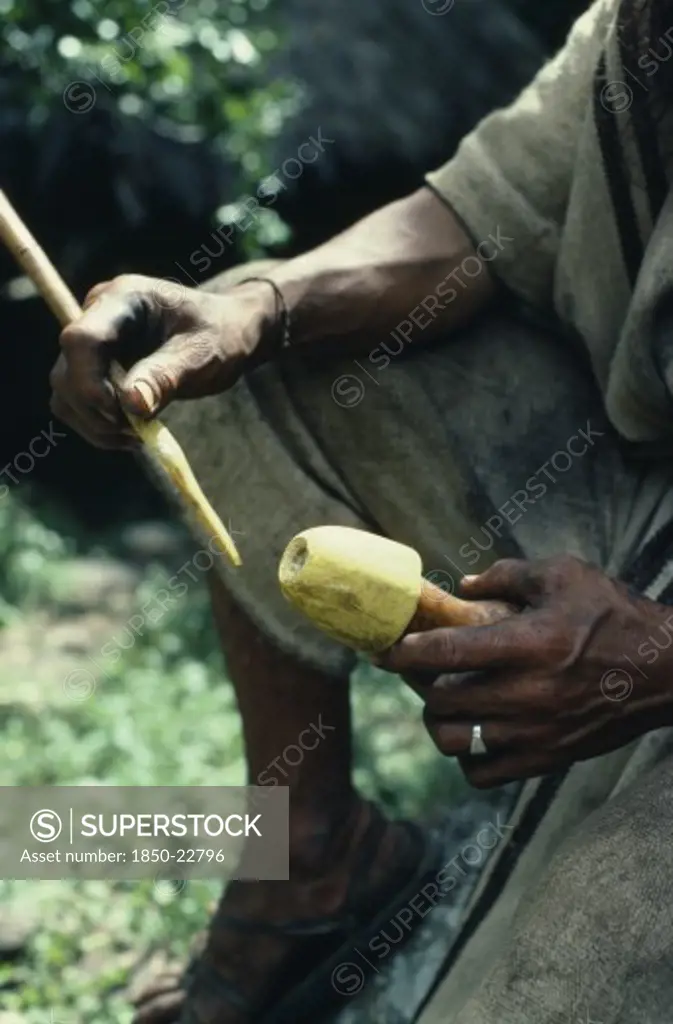 Colombia, Sierra Nevada De Santa Marta, Ika, Cropped Detail Of Ika Man Holding A Poporo Small Gourd Containing Finely Powdered Lime.Ika Men Can Spend Hours Rubbing Their Gourds With Their Palitos Small Sticks  In Ceremonies In Conversation Or In Thought.The Process Has A Deep Socio-Religious-Sexual Significance.The Stick Is The Male Penis  The Gourd The Female Vagina And The Rubbing The Sexual Act.The Lime Acts As A Catalyst To Extract Cocaine Alkaloid From Wad Of Chewed Leaves Constantly Held I