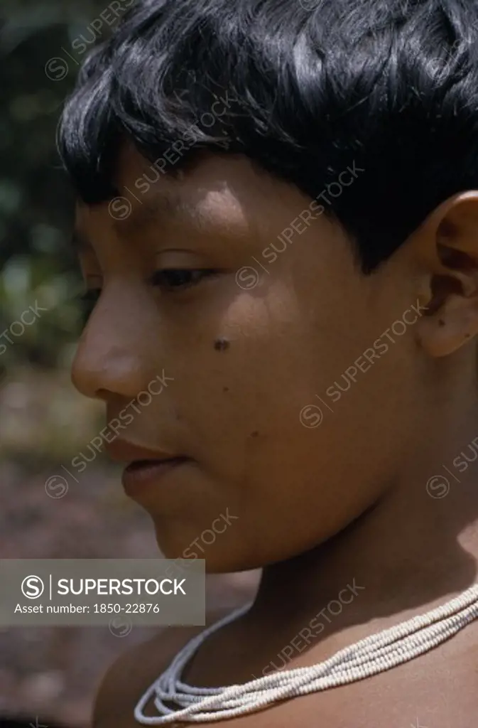Colombia, North West Amazon, Tukano Indigenous People, Head And Shoulders Portrait Of Barasana Boy  Profile To Left  Wearing Multi-Strand White Glass Bead Necklace.Tukano Sedentary Indian Tribe North Western Amazonia American Colombian Columbia Hispanic Indegent Kids Latin America Latino South America Tukano
