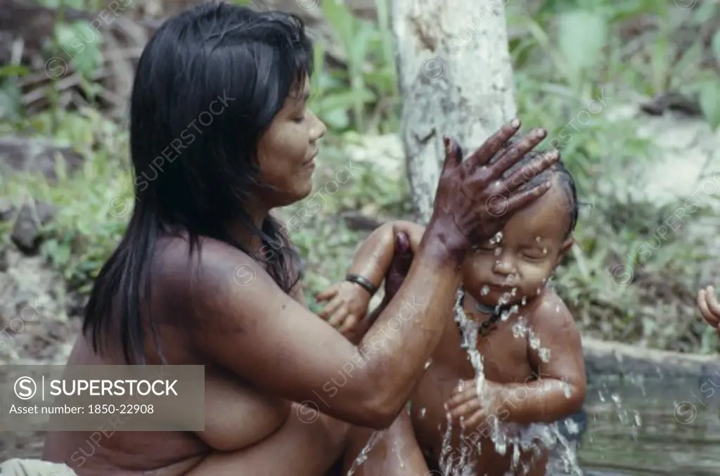 Colombia, North West Amazon, Tukano Indigenous People, Young Makuna Mother Washing Her Baby At The River Port. Tukano  Makuna Indian North Western Amazonia Family Cleaning Bathing American Babies Colombian Columbia Hispanic Indegent Kids Latin America Latino Mum South America Tukano