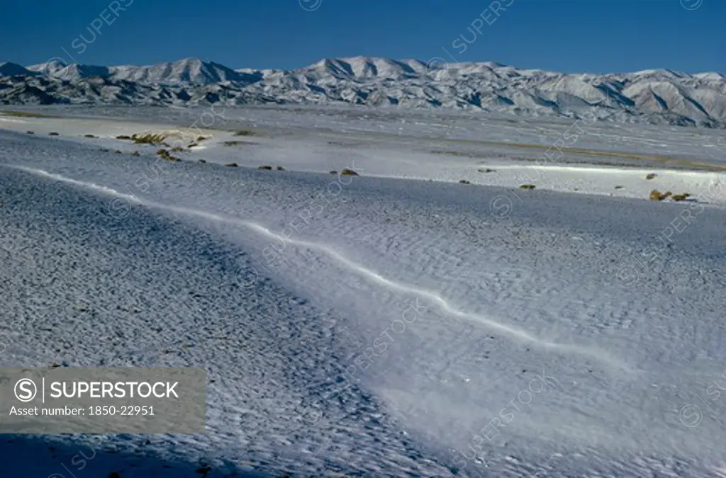 Mongolia, Gobi Desert, Biger Negdel, Mid-Winter With Snow-Covered Desert Pastures. Onvoy Of Trucks Brings Fodder To Outlying Negdel Collective. Altai Mountains In Background. East Asia Asian Mongol Uls Mongolian Scenic