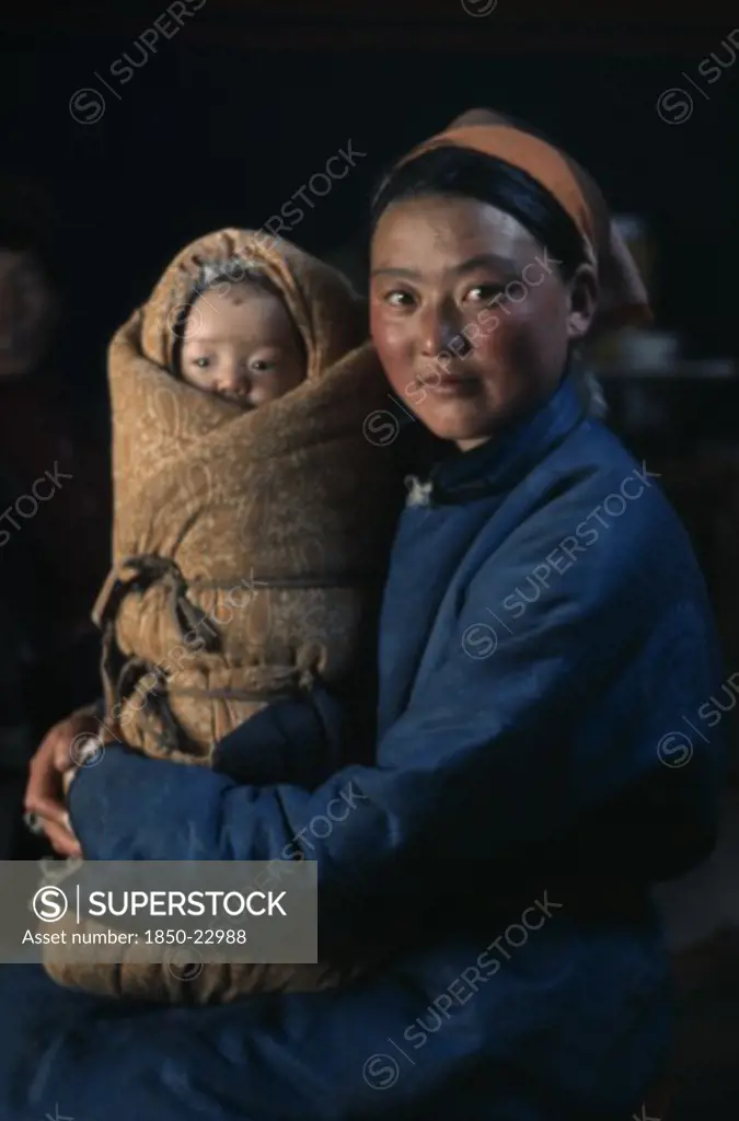 Mongolia, People, Young Mother In Fleece-Lined Silk Tunic Holding Baby Wrapped In Traditional Swaddling Against Bitter Winter Cold. East Asia Asian Babies Classic Classical Historical Kids Mongol Uls Mongolian Mum Older