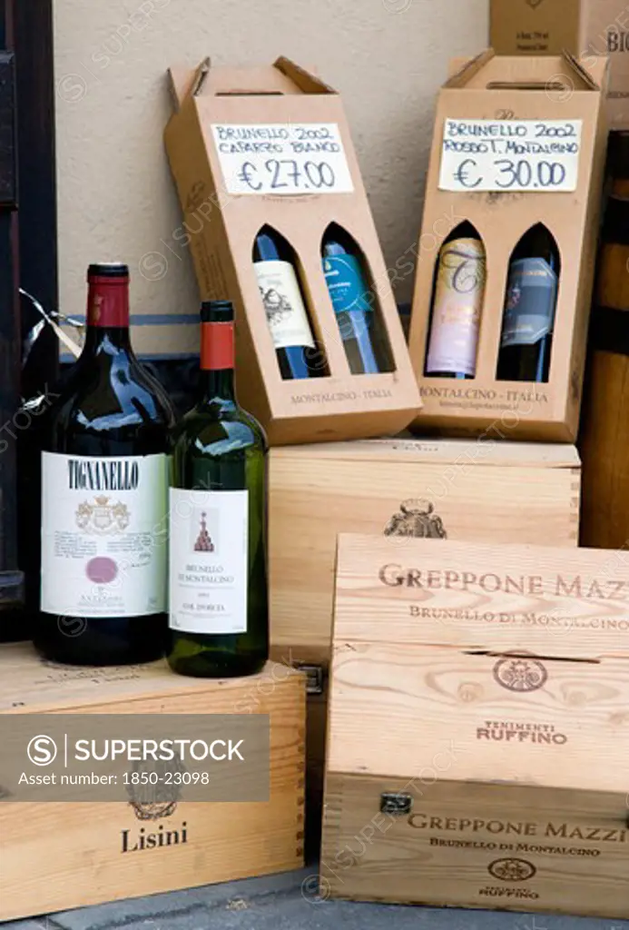 Italy, Tuscany, Montalcino, Wine Shop In The Medieval Hilltown With A Display Of Wine Bottles And Boxes Of Different Sizes With Prices Displayed In Euros