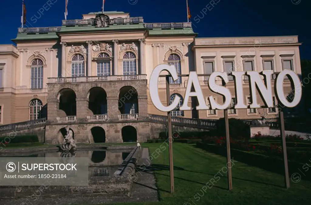 Austria, Salzburg, 'Klessheim Palace, Now The Salzburg Casino.  Baroque Exterior Dating From 18Th C. And Designed By Architect Fischer Von Erlach.  Lake, Statue And Sign For Casino.  '